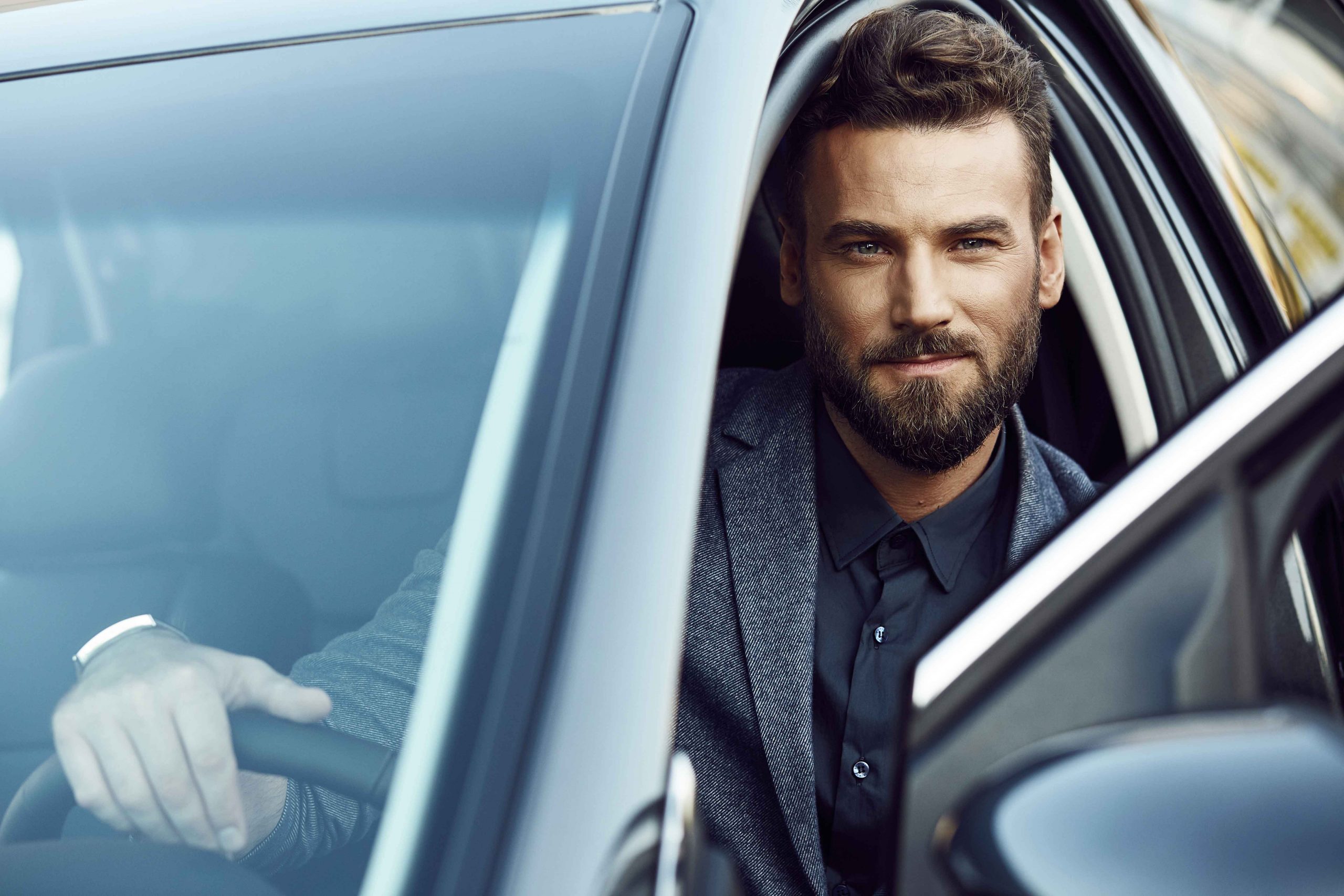 Hombre al volante con confianza tras comparar y mejorar su seguro de coche